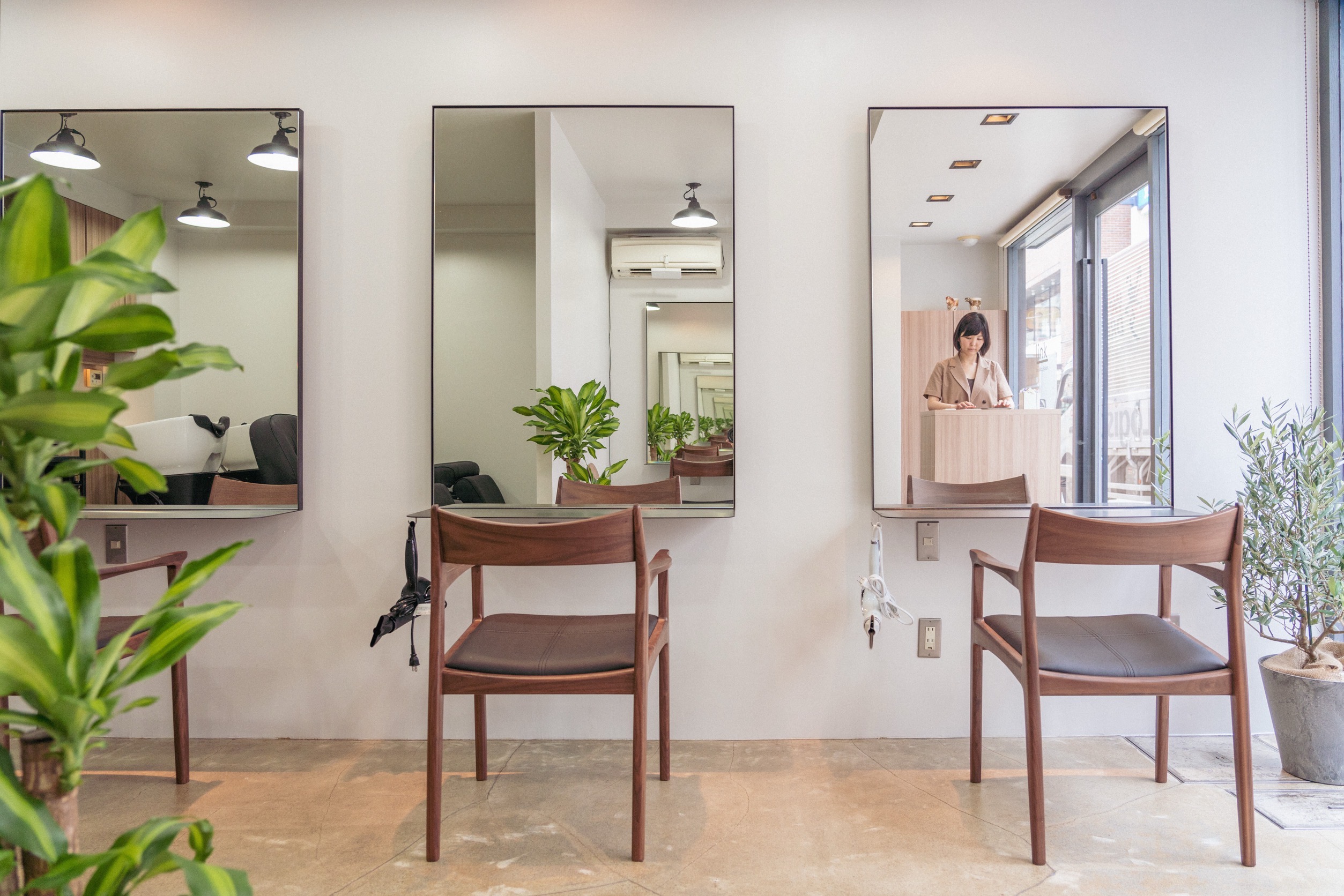 Beauty Salon Link 店内、三面の鏡とウォールナットの椅子が並ぶ落ち着いた空間
